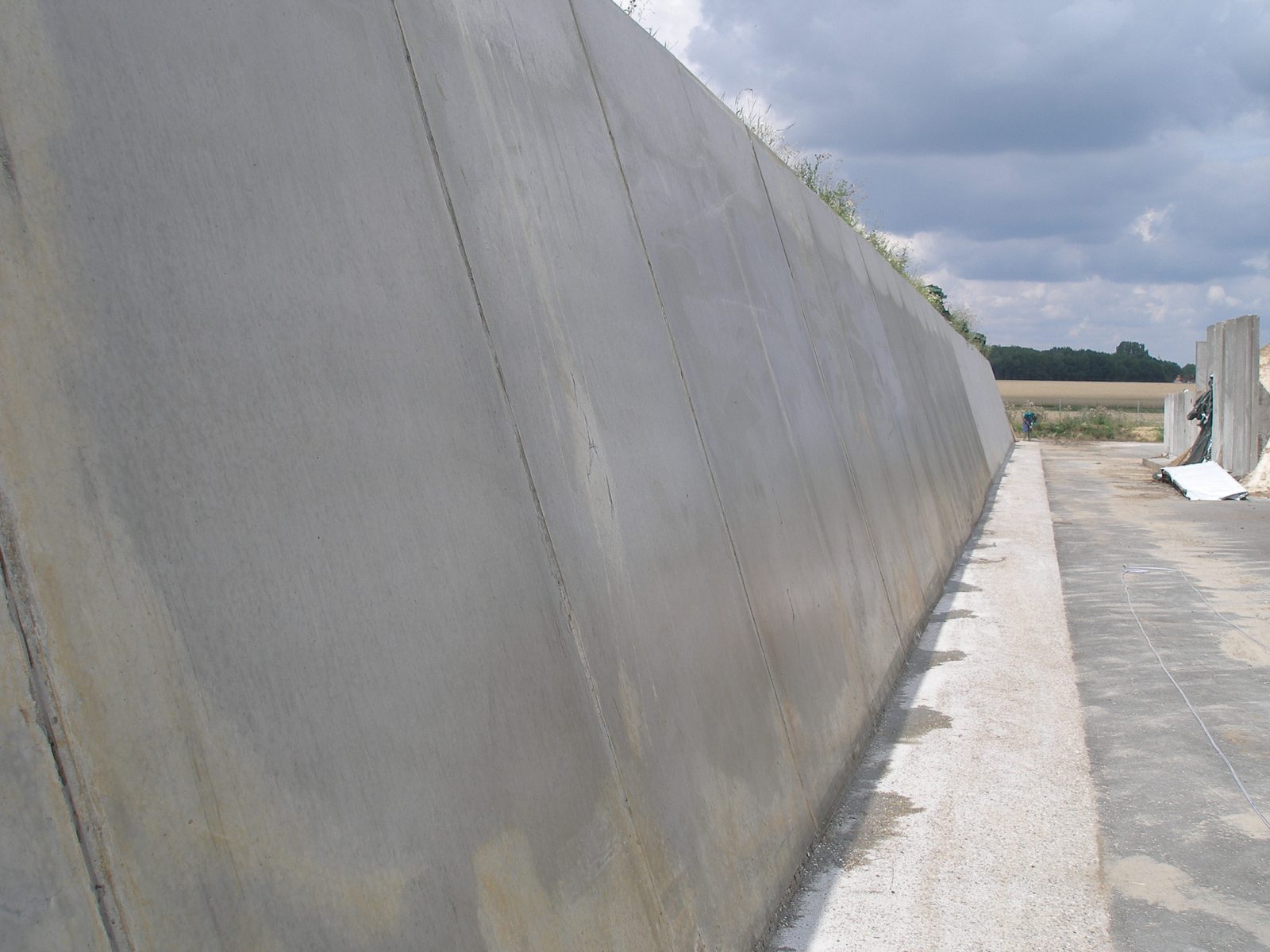Long retaining wall treated with Evercrete Vetrofluid, with the joints between pours visible